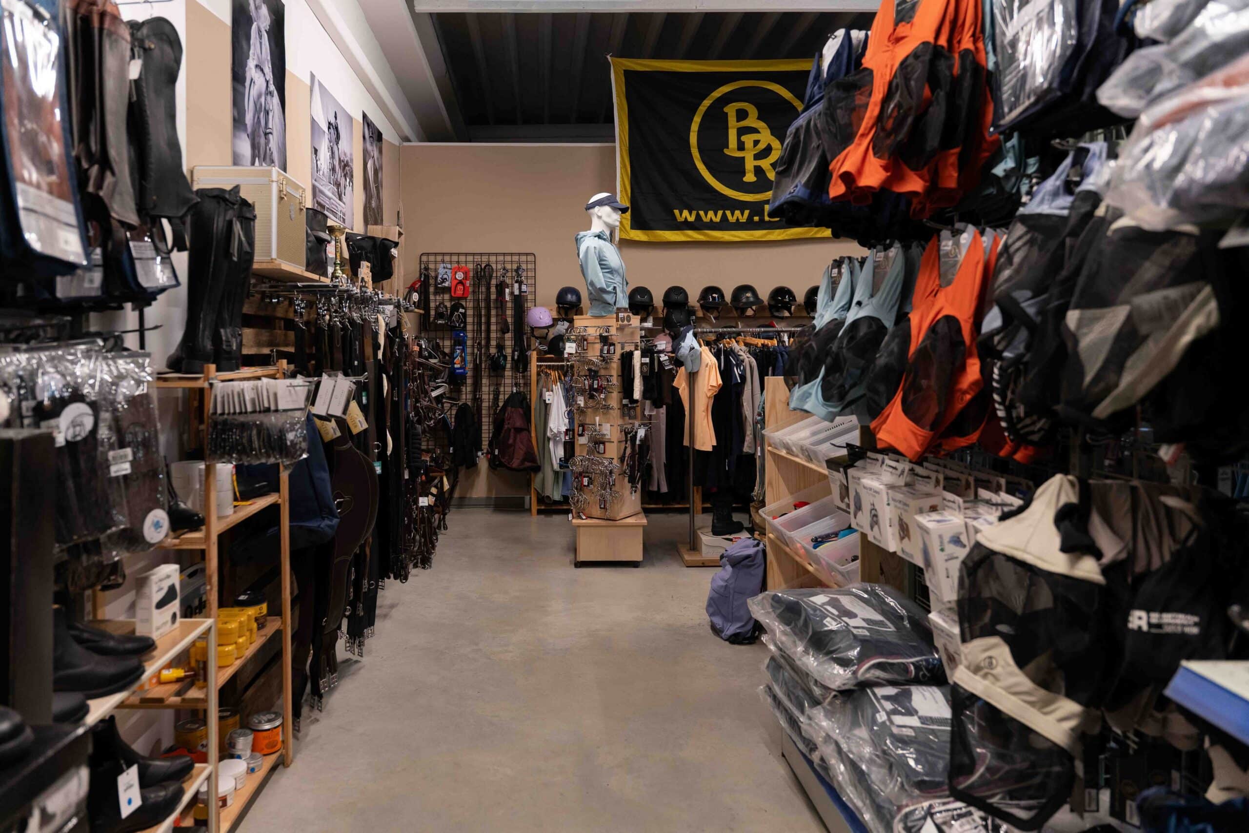 Rayon sellerie et intérieur du magasin Peyron avec équipements d'équitation et casques de protection